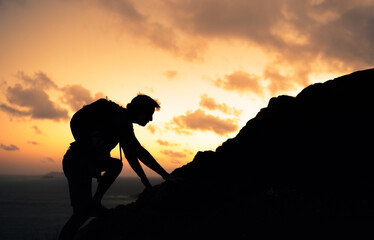 Man climbing up mountain cliff. will power, and taking risk concept. 