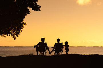 Wall Mural - Family relaxing together by the sea, Family summer vacation concept. 