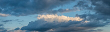 Banner With Panoramic View Over Deep Blue Rainy Sky With Illuminated Clouds As A Background.