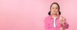 Image of serious, stylish asian girl in sunglasses, showing stop, prohibit gesture, taboo sign, saying no, standing over pink background
