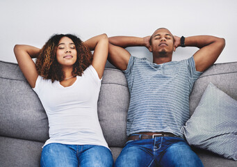 Aufkleber - Take time to take a timeout. Shot of a young couple resting on a couch at home.