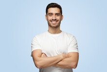 Young Smiling Attractive Man Stands With Arms Crossed Isolated On Blue Background