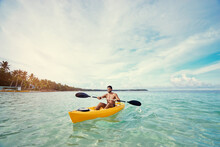 Young Strong Man Kayaking In The Sea Near The Tropical Island. Adventure By Kayak.