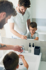 Sticker - Get rid of germs by washing your hands. Cropped shot of a young handsome father helping his adorable little boy wash his hands in the bathroom at home.