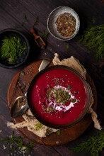 A Bowl Of Beetroot Soup Garnished With Cream, Dill, Pumpkin And Chia Seeds.