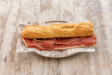 Cut the bread lengthwise and place the Serrano ham on one side and a couple of slices of brie cheese on top. To heat it you can do it on the grill, sandwich maker or in the oven.