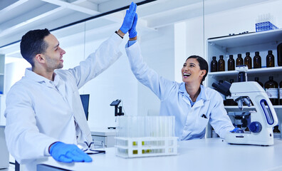 Wall Mural - we did it. cropped shot of two young scientists high fiving while working in their lab.