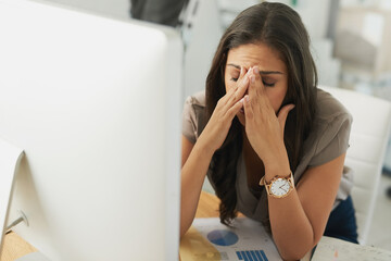 Poster - Shes starting to feel the pressure. Shot of an overwhelmed businesswoman sitting by her computer in the office.