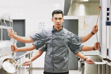 Everything a sous chef needs. Digitally altered portrait of a chef holding various cooking utensils in his kitchen.