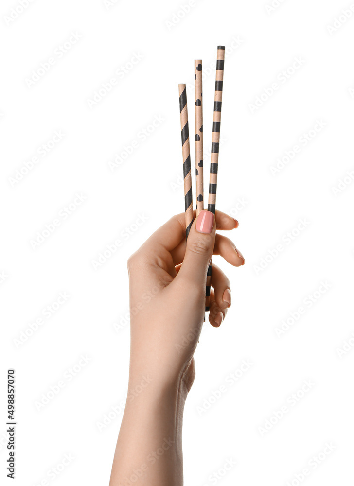 Female hand with stylish straws for drinks on white background