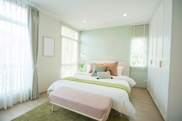 Wall Mural - Modern bedroom with green and pink pillows on bed. Stylish bedroom interior design.