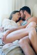 © AS/peopleimages.com - Safe in each others arms. Shot of a young couple enjoying a romantic moment on the sofa together in the morning.