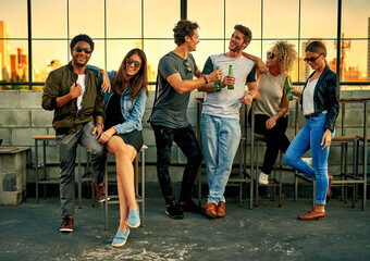 Sticker - Get together and let the good times roll. Shot of a group of young friends hanging out and having drinks together outdoors.