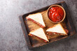 Sandwich with crispy bacon melted butter and ketchup close-up on a wooden tray on the table. horizontal top view from above