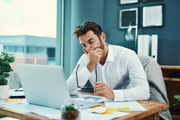 Aufkleber - Hes finding it tough to stay focused. Shot of a young businessman looking stressed out while working on a laptop in an office.