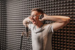 © Daria Lukoiko - The vocalist sings in the studio in a microphone. Man in headphones writes a podcast, an audiobook. Artist, recording an album, working with the label. Announcer records a speech at a radio station