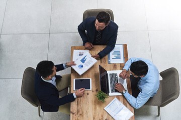 Poster - Running through the numbers together. High angle shot of three colleagues having a business meeting around a table in the office.