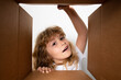 © Volodymyr - Kid unpacking and opening carton box, and looking inside with surprise face. Unpacking cardboard box for kids.
