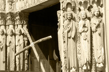  Cross And The Entrance To The Cathedral Of Chartres At Background. Selective Focus On The Figures Of Saints. Chartres, France. Sepia Historic Photo