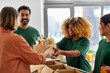 © Syda Productions - charity, donation and volunteering concept - happy smiling male volunteer with clipboard and woman taking box of food at distribution or refugee assistance center