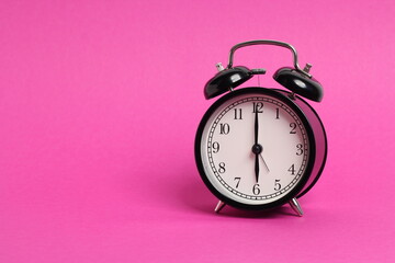 Wall Mural - vintage old black alarm clock on pink background