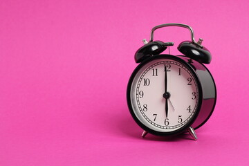 Wall Mural - vintage old black alarm clock on pink background