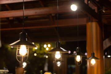 Wall Mural - Several vintage yellow pendant lights provide light at night.