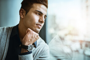 Poster - Who knows where success will lead him to next. Shot of a young businessman looking thoughtfully out the window in an office.