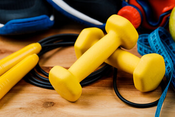 Sports equipment on a wooden table, weight loss and physical activity concept.