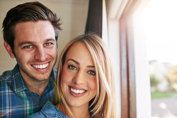 Poster - We found love. Cropped portrait of an affectionate young couple standing at a window in their home.