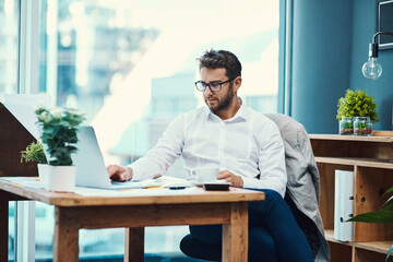 Aufkleber - Running a big business requires a focused effort. Shot of a young businessman working on a laptop in an office.