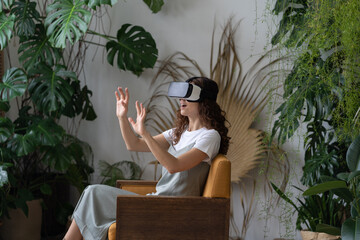 Overjoyed young woman wear vr glasses simulator enjoy experience from virtual reality headset for augmented simulation, gaming and futuristic entertainment at home. Using technology for video games