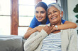 © Tamani Chithambo/peopleimages.com - Shes like a daughter to me. Portrait of a cheerful young female nurse holding a elderly patient in a wheelchair as support inside at home during the day.