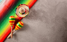 Cinco De Mayo Holiday Background Made From Maracas, Mexican Blanket Stripes Or Poncho Serape And Hat On Dark Stone Background.