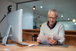 © Arnéll Koegelenberg/peopleimages.com - He always reads the fine print. Shot of a smiling mature businessman reading paperwork while sitting at his desk in an office.