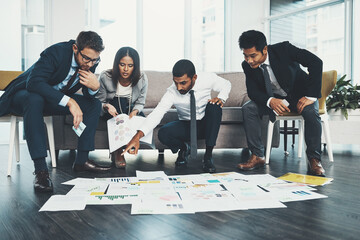 Poster - We make the best decisions when were together. Shot of businesspeople having a brainstorming session with documents spread out in front of them.