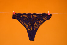 Lace Panties. The Sexy Panty Isolated On The Yellow Background. Black Silk Lacy Panty, Woman Underwear, Sexy Lingerie. Thong Bikini Panties Underwear Lingerie.