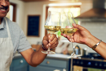 Wall Mural - Bon appetit. Cropped shot of a mature couple toasting with wine in the kitchen at home.