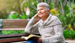 © Sean A E/peopleimages.com - Nothing like reading a book in peace. Cropped shot of a cheerful elderly woman reading a book by herself outside in a park.