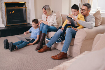 Sticker - In need of a better data plan. Shot of a young family bonding while using their electronic devices together at home.