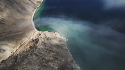 Wall Mural - Beautiful shore of Baikal lake with clear blue water. Clouds over the lake and mountains in misty morning. Aerial drone view. Baikal lake, Siberia, Russia. Beautiful spring landscape. 
