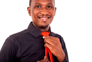 Wall Mural - young businessman standing and knotting a red tie while smiling.