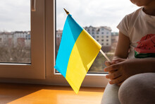 Girl With The Flag Of Ukraine In Her Hands Looks Out The Window