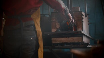 Wall Mural - Blacksmith workshop - a man puts metal thing in the oven