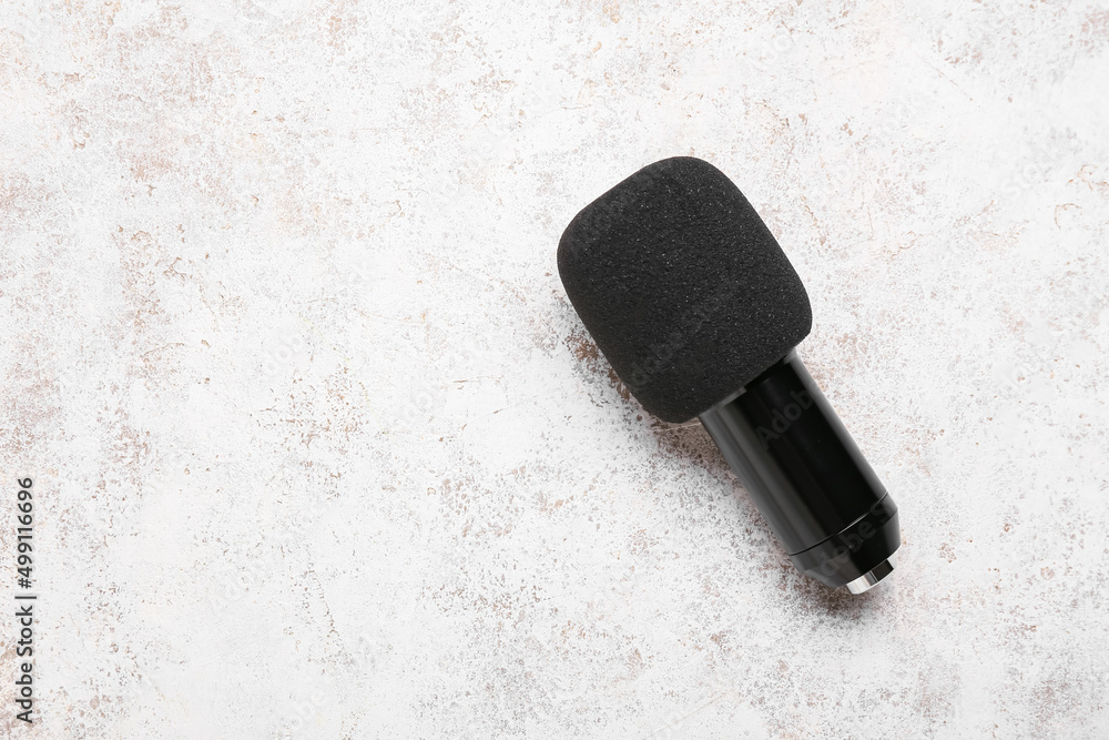 Modern microphone on light background