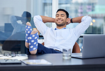 Sticker - Basking in glory. Shot of a very satisfied businessman relaxing at his desk at work.