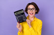 © deagreez - Photo of hooray millennial lady hold calculator wear yellow outfit spectacles isolated on violet color background
