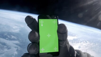 Wall Mural - view through the helmet, astronaut using his mobile phone during the spacewalk. green screen chroma 