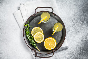 Traditional italian limoncello liqueur, lemon alcohol Digestive with lemon and rosemary. White background. Top view