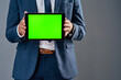 © K Seisa/peopleimages.com - The perfect place to display your business ideas. Studio shot of an unrecognizable corporate businessman holding a tablet against a grey background.
